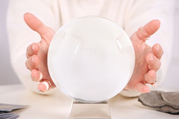 Eine weiße Glaskugel mit Händen rechts und links